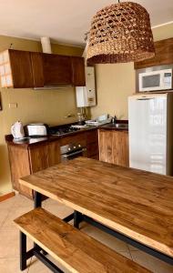 a kitchen with a wooden table and a refrigerator at Blumen Hotel in Concón