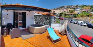 balcón de una casa con bañera de hidromasaje y sillas en Casa Ascenção, vista mar Madeira en Funchal