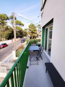 - Balcón con mesa y bancos en un edificio en Appartement vue mer en Saint-Georges-de-Didonne