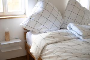 Schlafzimmer mit einem Bett mit weißer Bettwäsche und Kissen in der Unterkunft Concordia33 - Traumferienwohnung an der Regnitz in Bamberg