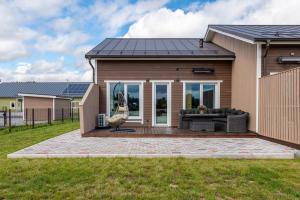 a house with a solar roof on a patio at Ridaelamuboks järve ääres in Nõo