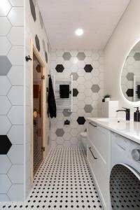 a bathroom with black and white hexagonal tiles at Ridaelamuboks järve ääres in Nõo