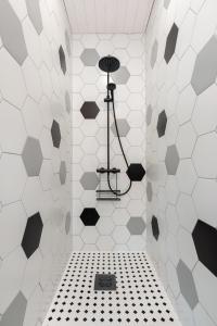a bathroom with a black and white tiled wall at Ridaelamuboks järve ääres in Nõo