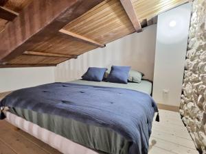 a bedroom with a large bed with blue pillows at LE RELAIS DE CRUSSOL in Saint-Péray