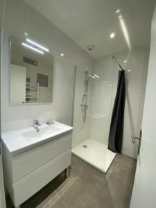 a white bathroom with a sink and a shower at LE RELAIS DE CRUSSOL in Saint-Péray
