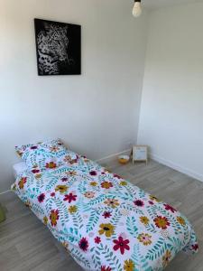 1 cama con edredón de flores en un dormitorio en Appartement idéal famille 3 chambres, en Mâcon