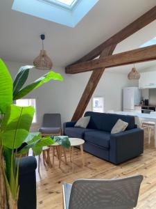 uma sala de estar com um sofá azul e uma mesa em LE RELAIS DE CRUSSOL em Saint-Péray