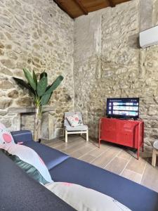 um quarto com uma cama e uma parede de pedra em LE RELAIS DE CRUSSOL em Saint-Péray