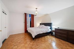 een slaapkamer met een bed en een houten vloer bij Private Oasis for Ultimate Relaxation in Montreal