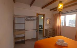 MácherにあるLuxury Suite Volcan Iのベッドルーム(オレンジ色のベッド1台、クローゼット付)