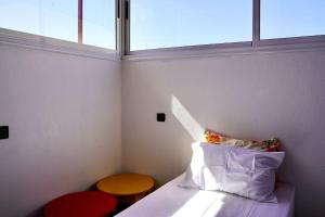 a small room with a bed and a window at Surf House Desert Point in Tiguert