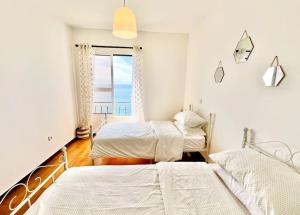 ポンタ・ド・ソルにあるApartment Paulo by Your Madeira Rentalsの海の見えるベッドルームにはベッドが2つあります