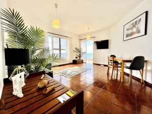 ポンタ・ド・ソルにあるApartment Paulo by Your Madeira Rentalsのテーブルとダイニングルームのあるリビングルーム