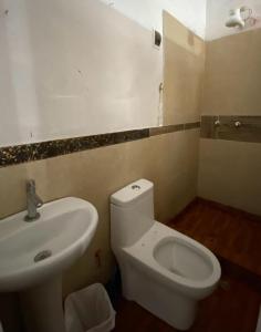 uma casa de banho com um WC branco e um lavatório. em Mindepartamento Céntrico em Cajamarca