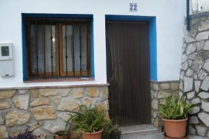 un bâtiment avec une porte et deux plantes en pot dans l'établissement Casa La Chelva, à Alcudia de Veo