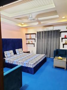 1 dormitorio con 1 cama y suelo azul en Anabi Apartments and Suits E11 Islamabad en Islamabad