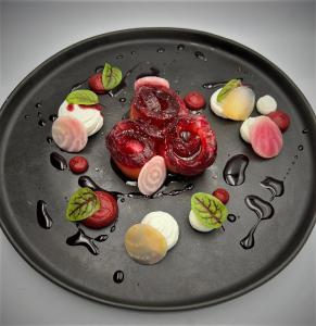 a black plate of food with strawberries and marshmallows at Domaine de la Résidence - Hôtel, Spa & Restaurant in Moulins-lès-Metz