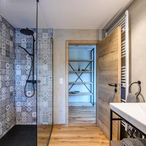 a bathroom with a walk in shower and a glass door at Design Apartment an der Via Claudia 