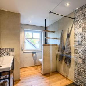ein Bad mit einer Dusche, einem WC und einem Fenster in der Unterkunft Design Apartment an der Via Claudia 