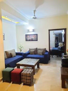 sala de estar con sofá azul y mesa en Anabi Apartments and Suits E11 Islamabad en Islamabad