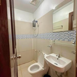 a bathroom with a toilet and a sink at Earl De Princesa Hotel in Puerto Princesa City