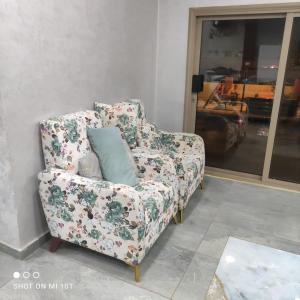 a floral chair in a room with a mirror at Raghad Chalet in Jerash