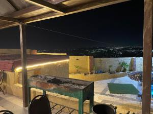 eine Außenterrasse mit einem Tisch und Stühlen in der Nacht in der Unterkunft Raghad Chalet in Gerasa
