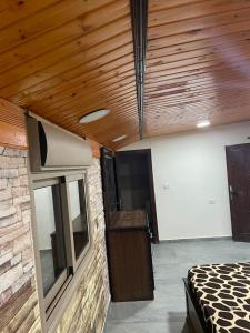 Cette chambre comprend un lit et un plafond en bois. dans l'établissement Raghad Chalet, à Jerash