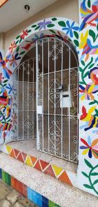 a cage on the side of a building with a mural at Villas Velarde in Cozumel