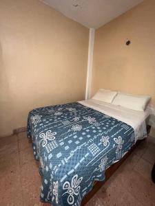 a bedroom with a bed with a blue and white blanket at Villas Velarde in Cozumel