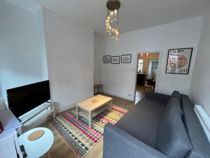 a living room with a couch and a table at Altrincham Terrace - 2 Bedroom House - Free Parking - Sleeps 6 - Near Tram Stop in Manchester