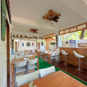 - un restaurant avec des tables et des chaises dans une salle dans l'établissement Earl De Princesa Hotel, à Puerto Princesa