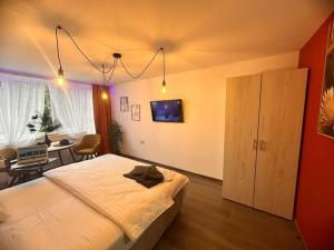 a bedroom with a large white bed and a table at Residence 57 in Reşiţa