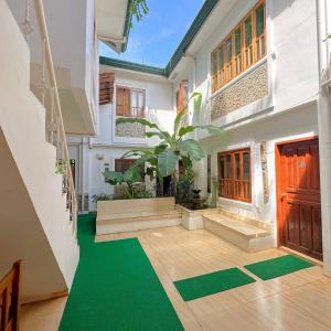a room with a green floor and a building at Earl De Princesa Hotel in Puerto Princesa City