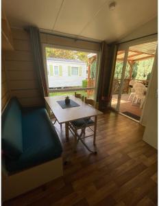 a living room with a table and a couch and a patio at Mobile home proche de Europa Park in Boofzheim