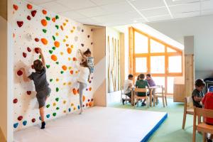 a group of children playing on a climbing wall at Résidence Club MMV Le Silvana in Risoul