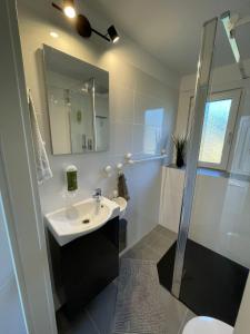 a white bathroom with a sink and a shower at CASALINO DI ANNA 2 in Wensickendorf