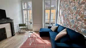 uma sala de estar com um sofá azul e uma lareira em L'authentique em Autun