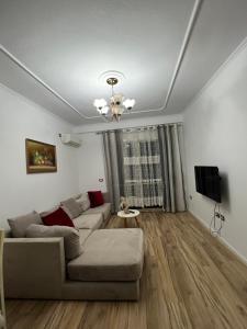 uma sala de estar com um sofá e uma televisão em Cozy apartment at Sunny Hill em Tirana
