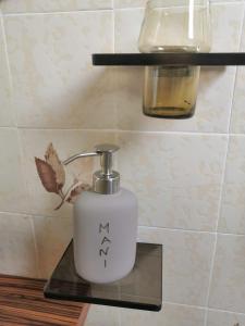 a white soap dispenser sitting on a shelf in a bathroom at Apartment La Marina near the sea in Varazze
