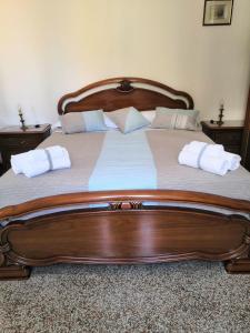 a large wooden bed with two pillows on it at Apartment La Marina near the sea in Varazze +25 photos