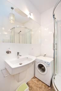 a white bathroom with a washing machine and a sink at YOURAPART Gdańsk Starówka in Gdańsk