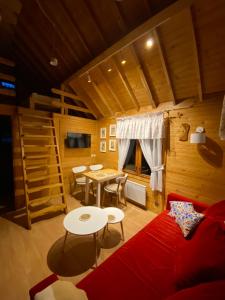 a living room with a red couch and a table at Verde Land - Drewniany domek na wsi in Osiek Mały