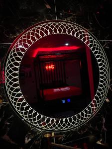 a mirror with a red bed in a room at Chambre Romantique avec Jacuzzi R in Gruny