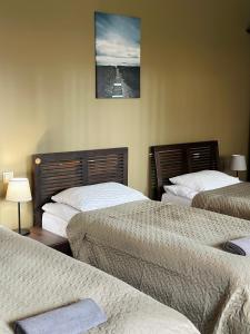 um quarto de hotel com duas camas e uma foto na parede em Viesnīcas Jolanta apartamenti em Kolberģi