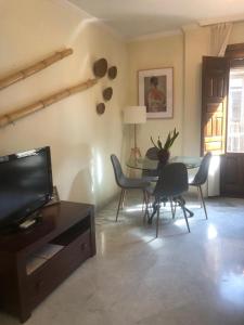 een woonkamer met een tafel en stoelen en een televisie bij Centro ciudad y parking in Granada +8 foto's