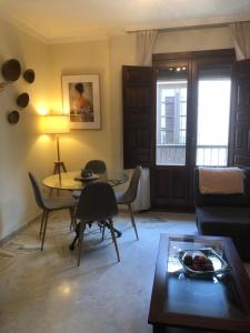 een woonkamer met een bank, een tafel en stoelen bij Centro ciudad y parking in Granada