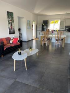 uma sala de estar com um sofá e mesas e uma cozinha em Résidence Lilas Rose em Andilana