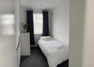 a small bedroom with a bed and a window at Crown Road Apartment in Kent