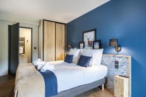 a bedroom with a large bed with blue walls at Résidence Club MMV Le Silvana in Risoul +63 photos